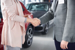 Lemon car buyer discussing a vehicle purchase with a car salesperson at a dealership